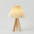 Wooden table lamp with pleated shade on a light gray background