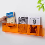 wall-mounted magazine and book display shelf in orange